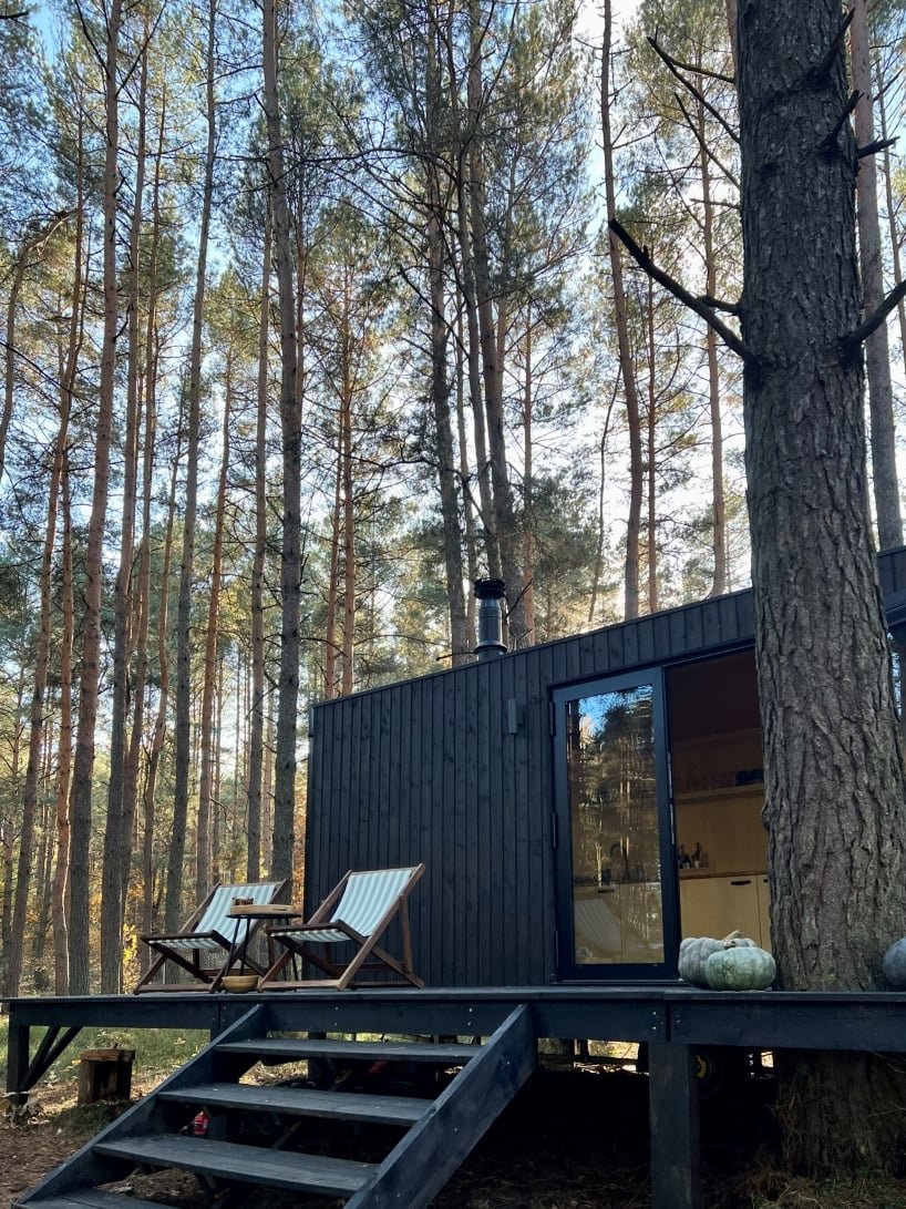 darkened plywood coats REDUKT's mobile tiny cabin offering an off-grid retreat