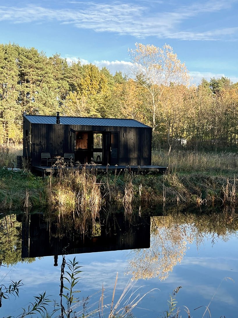 darkened plywood coats REDUKT's mobile tiny cabin offering an off-grid retreat