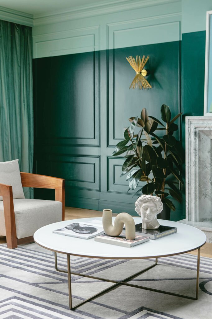 a coffee table atop a rug in the teal sitting room