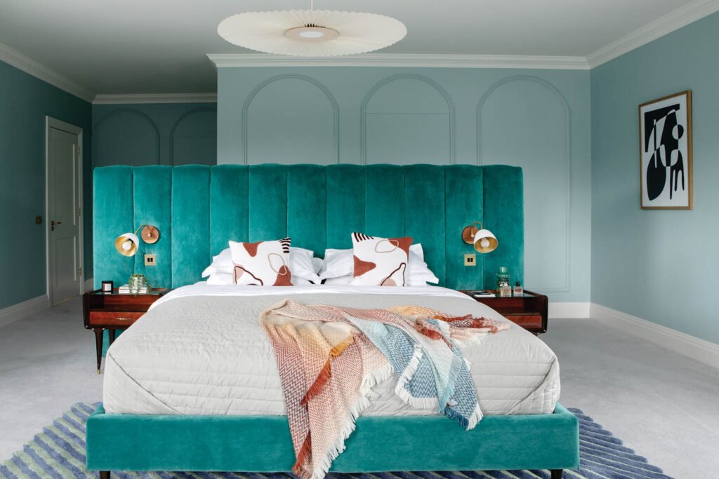 a teal velvet-upholstered bed in the main bedroom of a Dublin home designed by DesignLed