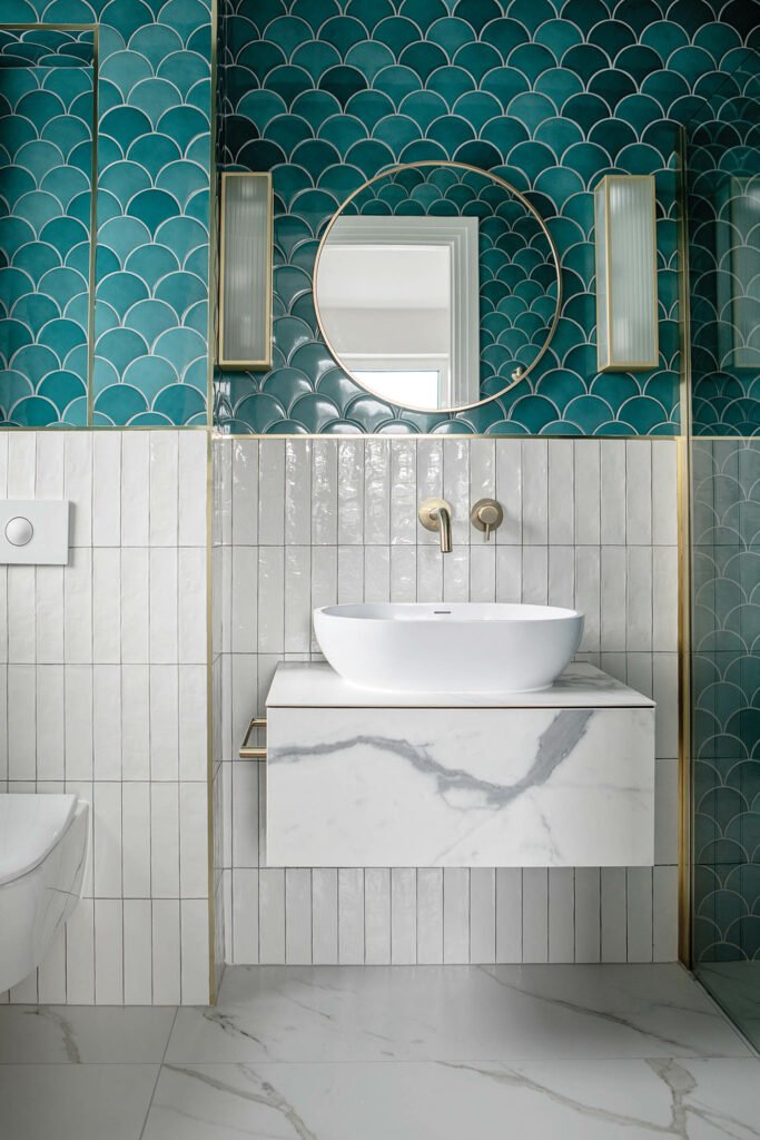 two types of ceramic tile, white and teal, are found in the powder room