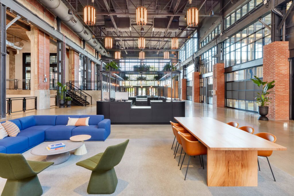 communal work area with a long wood table and blue couch