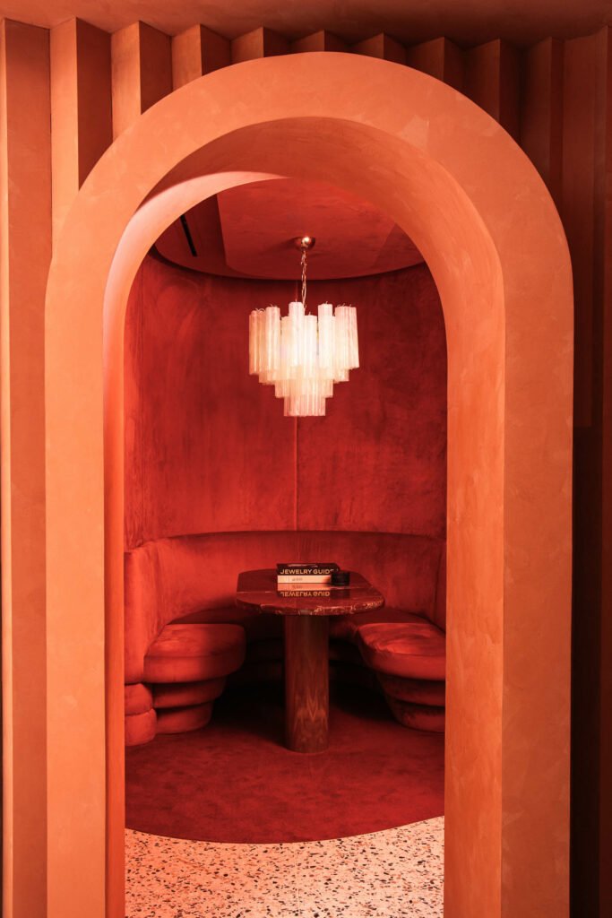 an arched doorway leads to a deep red sitting room