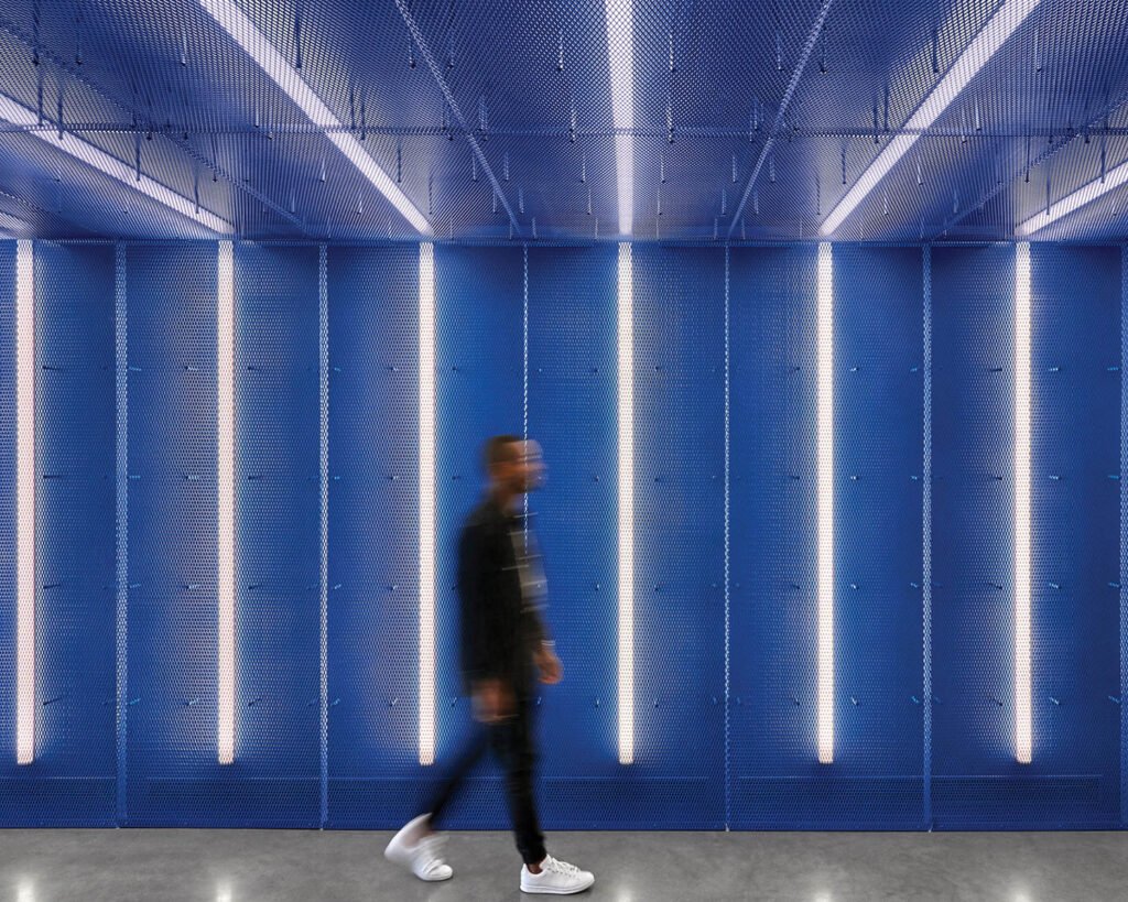 a person walks down a blue hallway with led light stripes