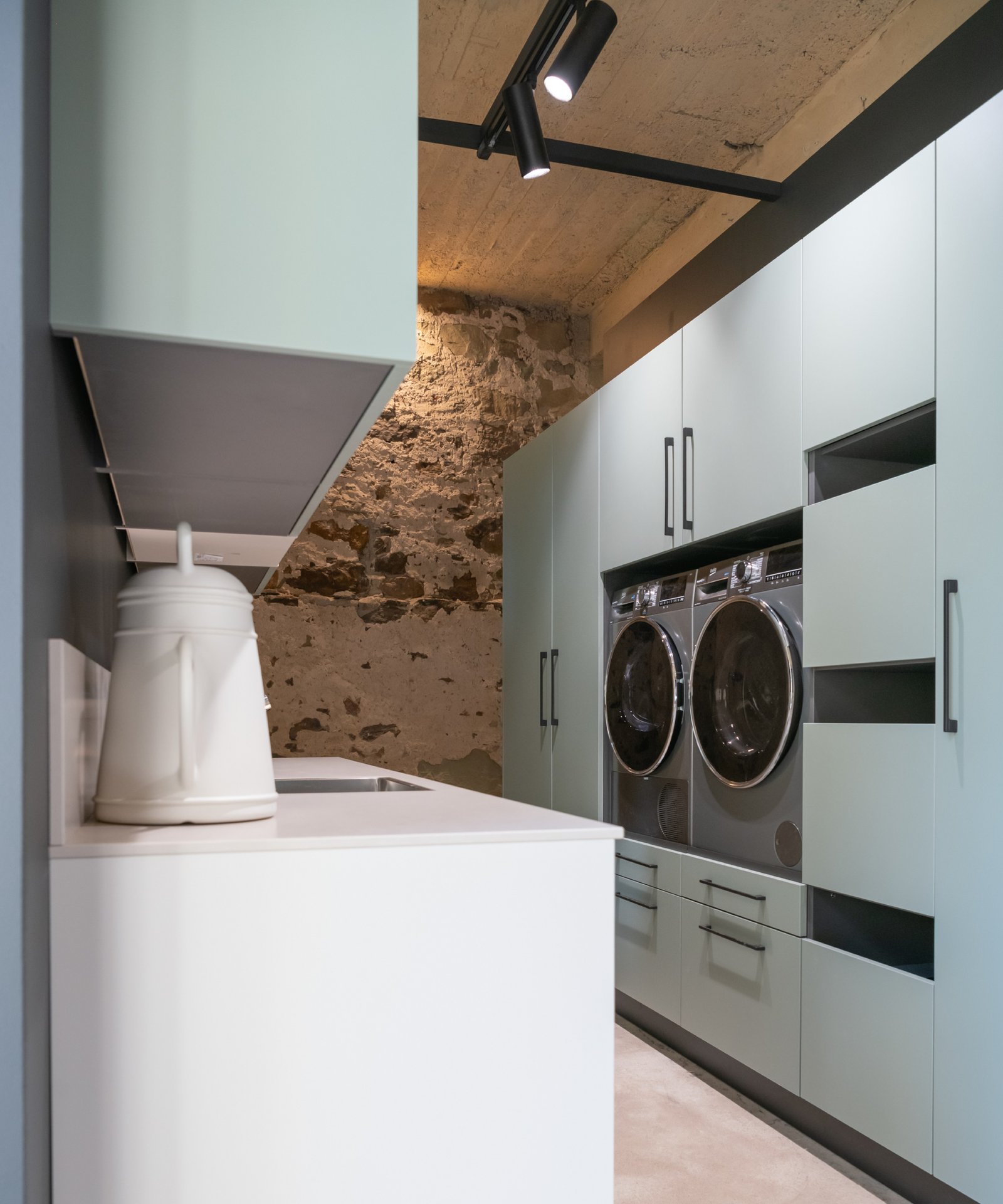 pale green utility room cupboards with washing machine and tumble drier