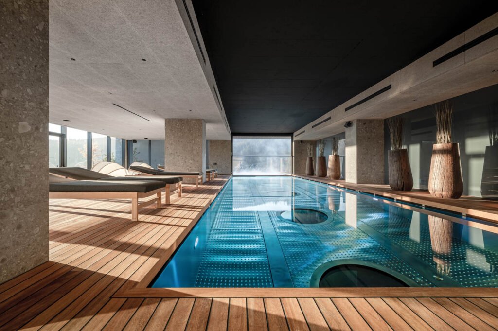 indoor portion of the pool with sand chaise lounges