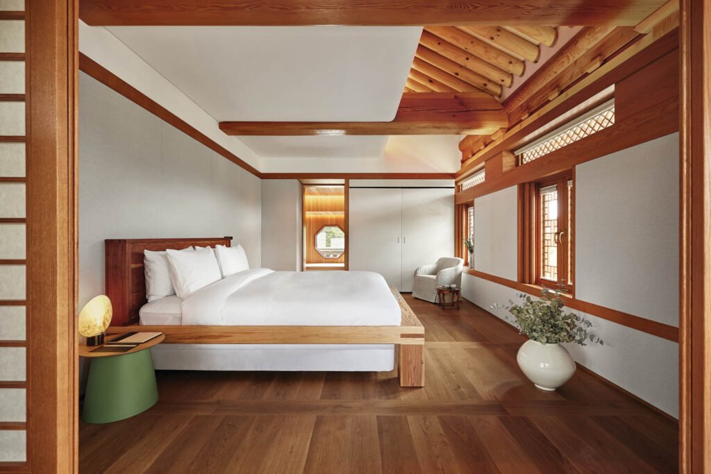 a guest bedroom with wood floors and wood beam ceiling