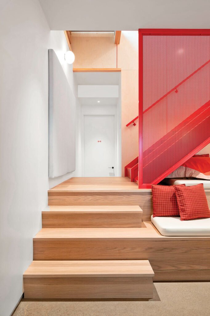 stairway entry with wooden stairs and red screens