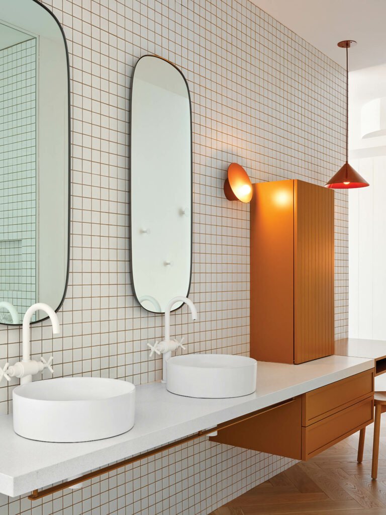 bathroom with white tiles, dual mirrors and dual sinks