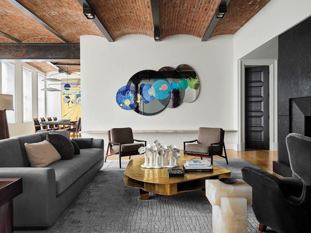living room with black lounge chairs and a colorful cloud-like wall piece
